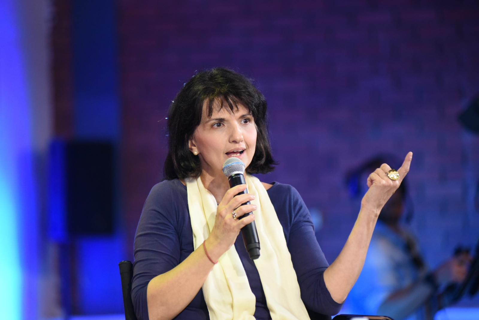 Ομιλήτρια κρατά το μικρόφωνο στις Συζητήσεις των Διαλόγων ΙΣΝ.