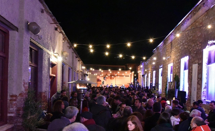 Το μεγάλο πλήθος συγκεντρωμένο έξω σε μια αυλή με έντονα φώτα από πάνω τους