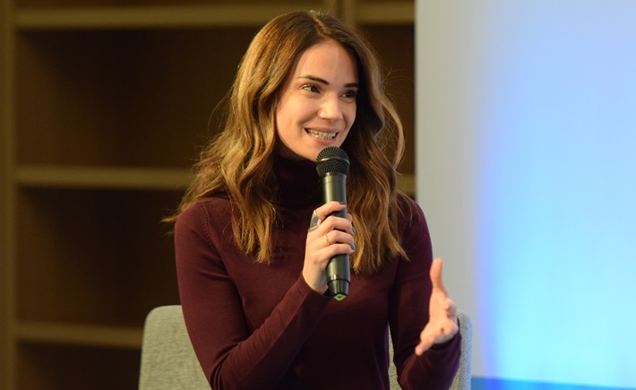 Η Άννα Κύνθια Μπουσδούκου κρατά το μικρόφωνο και μιλά στη συζήτηση των Διαλόγων ΙΣΝ.