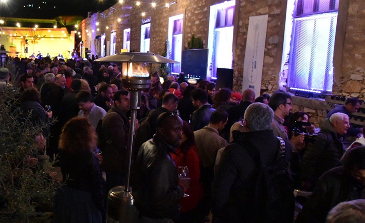 Το μεγάλο πλήθος συγκεντρωμένο έξω σε μια αυλή με έντονα φώτα από πάνω τους