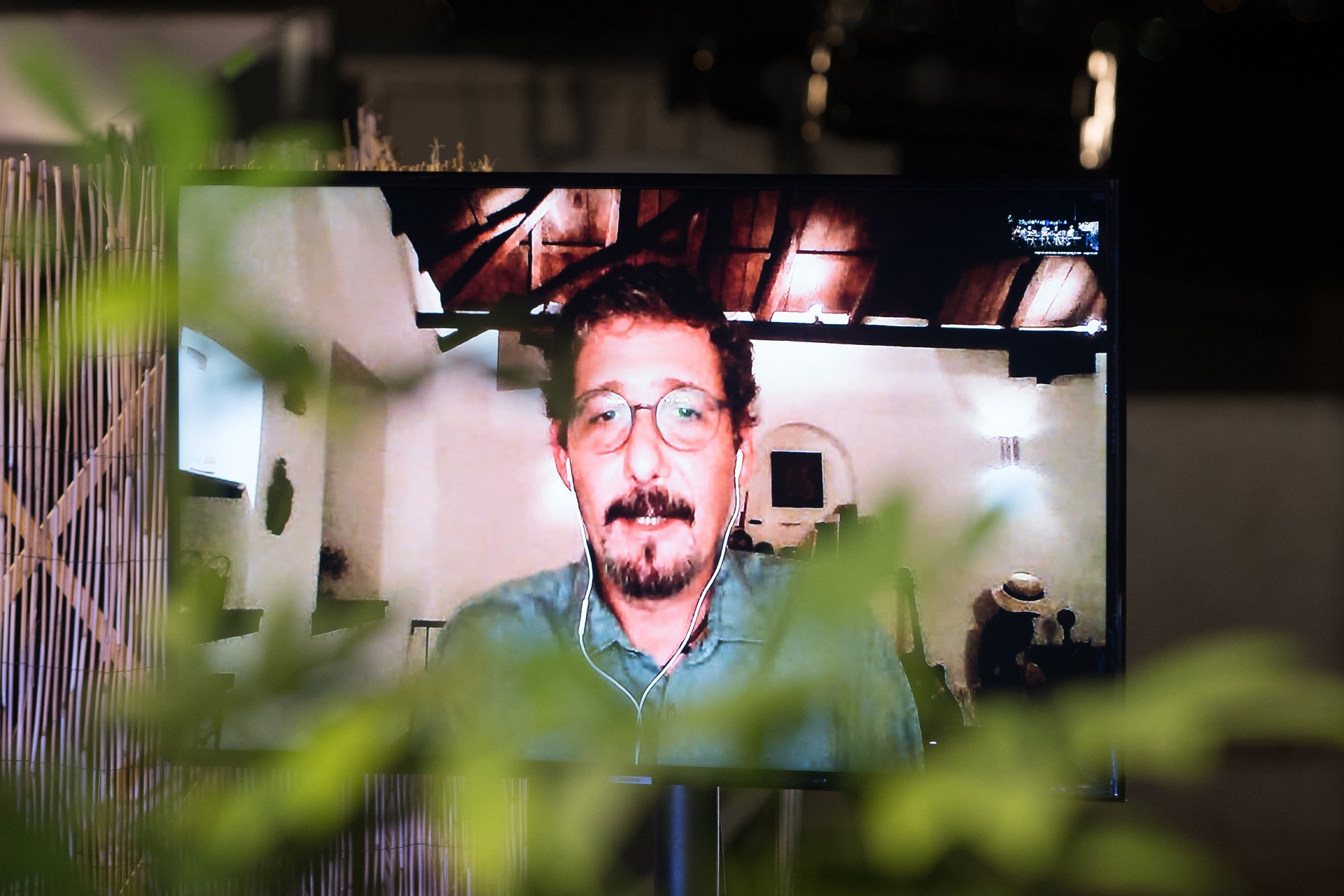 A screen showing a man at the SNF Dialogues event.