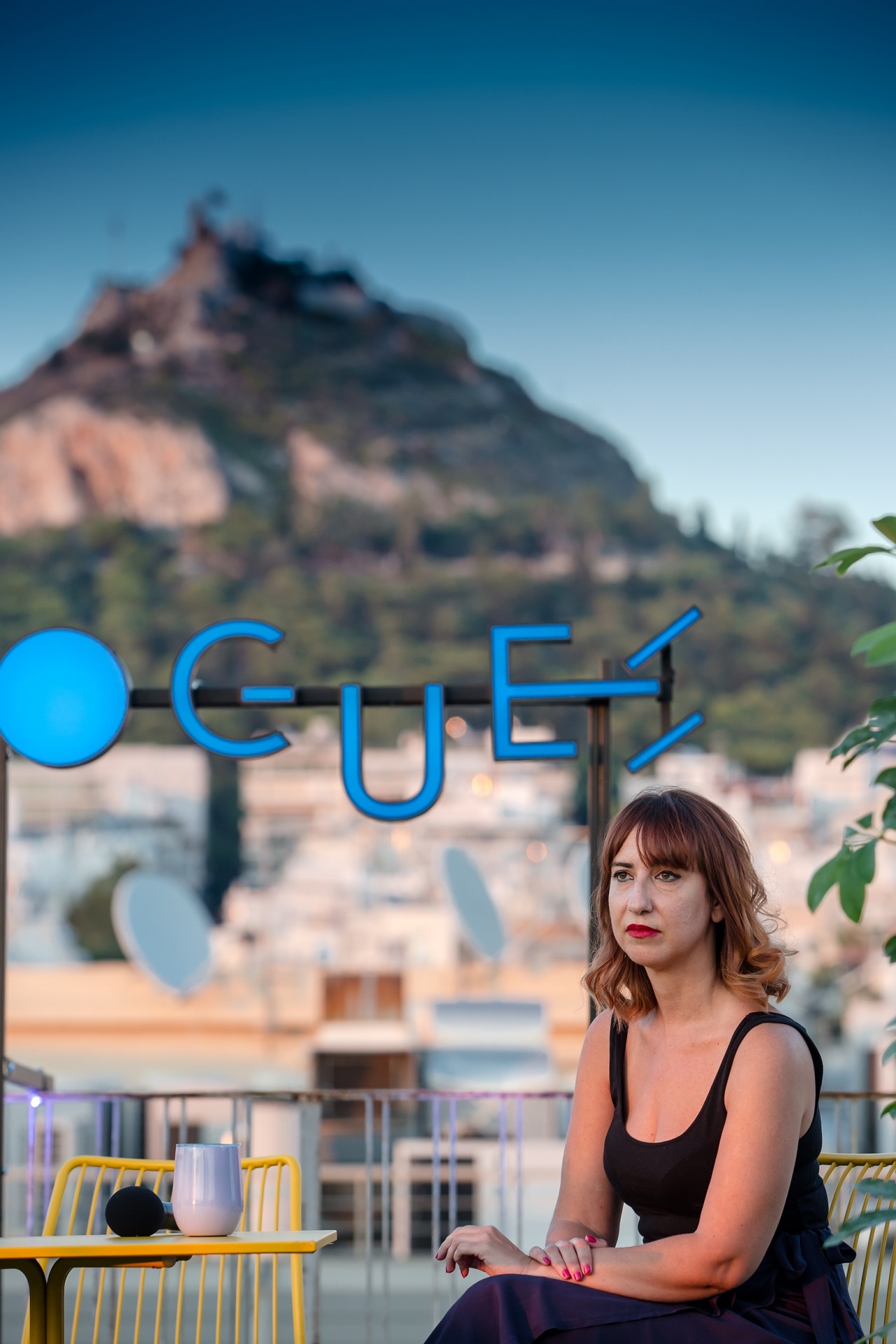 A woman with the Athenian urban landscape as a background.