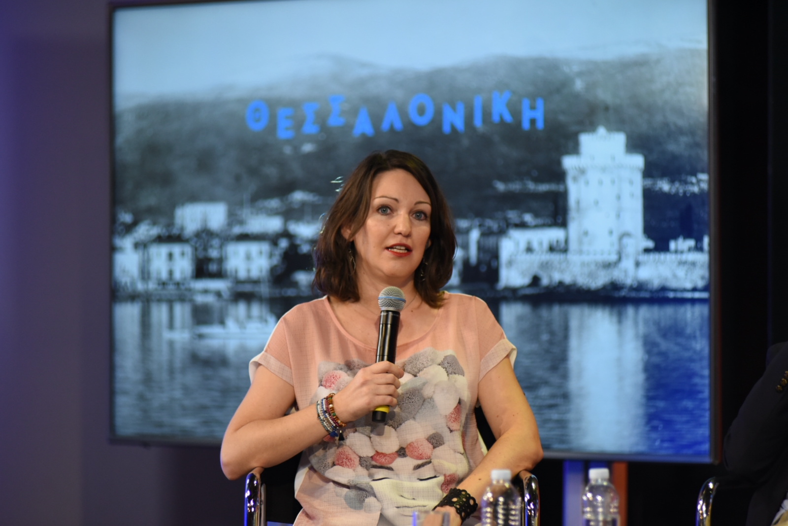 Ομιλήτρια κρατά το μικρόφωνο στις Συζητήσεις των Διαλόγων ΙΣΝ.