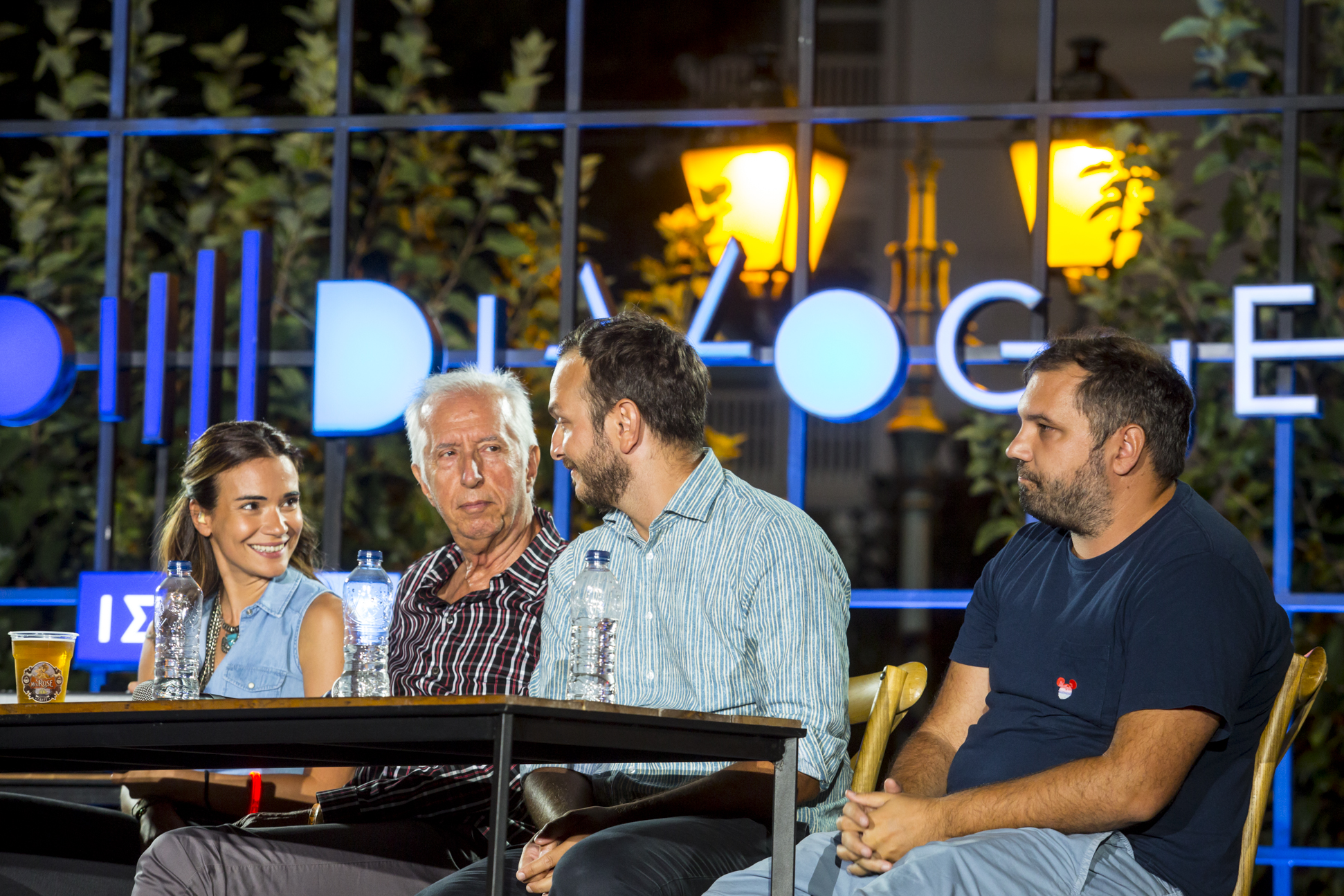 Anna Kynthia Bousdoukou smiling at three guest speakers at the SNF Dialogues event.