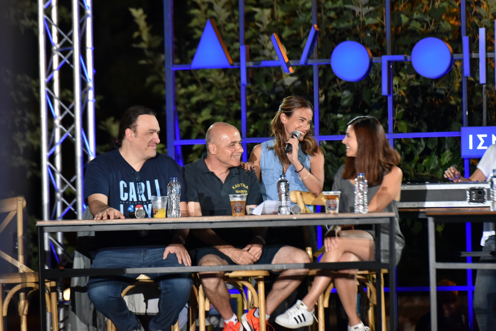 Anna Kynthia Bousdoukou smiling at three guest speakers at the SNF Dialogues event.