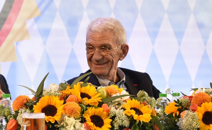Photo of a man at the SNF Dialogues event in front of a bouquet of flowers