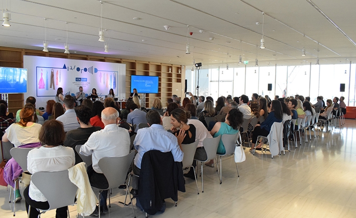 Ακροατές στη συζήτηση Διαλόγων ΙΣΝ που κοιτά τη σκηνή όπου βρίσκονται πέντε ομιλητές.