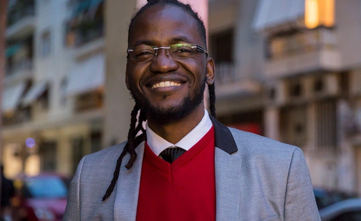 A man smiling wide and posing for a photo