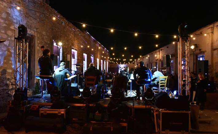 Μουσικοί που παίζουν στη σκηνή στην αυλή του κτιρίου 