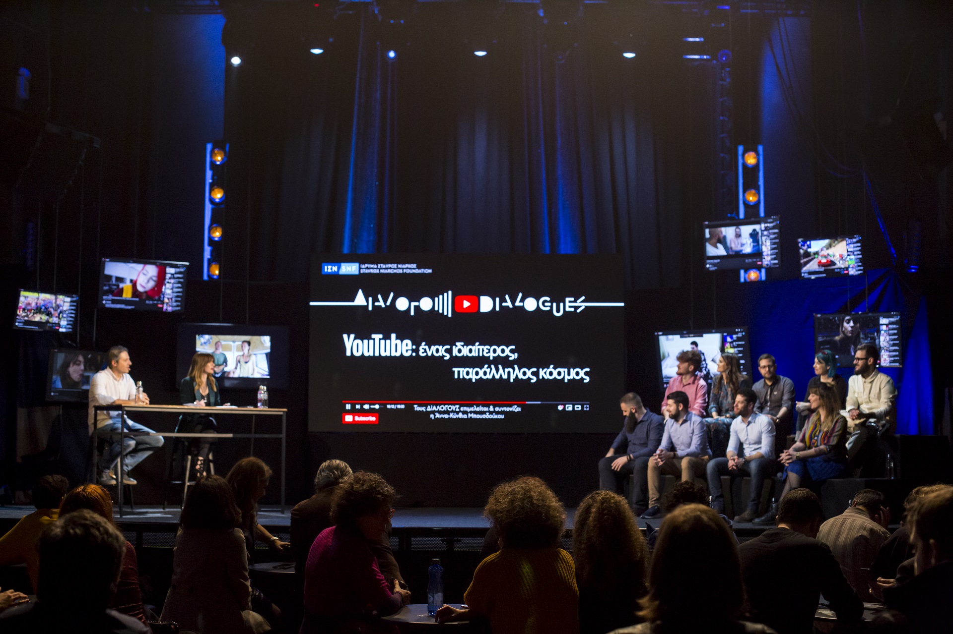 Άννα Κύνθια Μπουσδούκου και ομιλητές με μια μεγαλη οθόνη στη μέση στη συζήτηση των Διαλόγων ΙΣΝ.