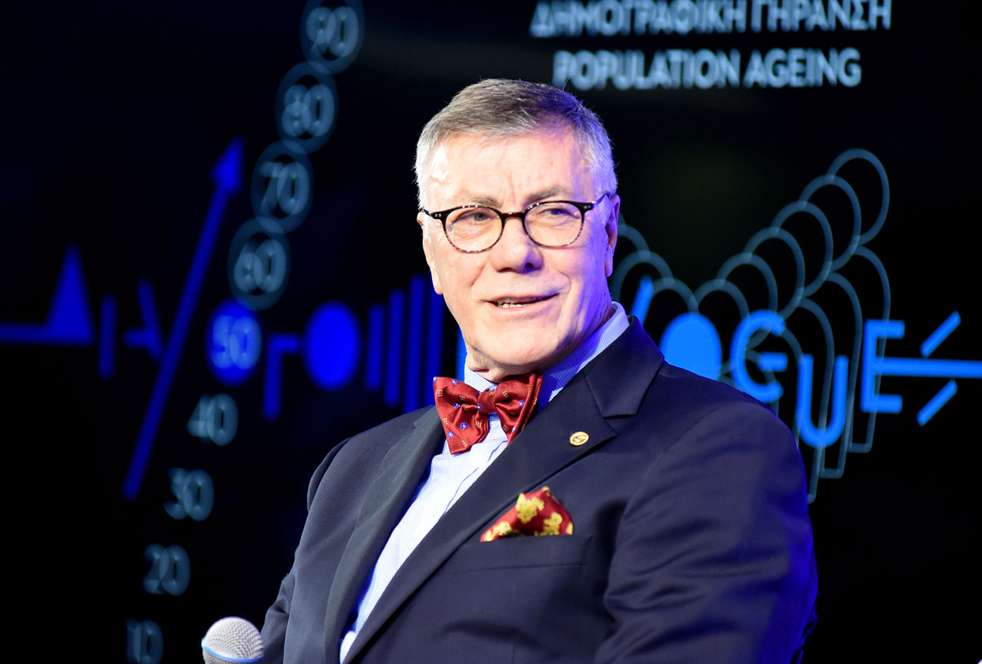 Ένας άνδρας που μιλάει στο μικρόφωνο στη συζήτηση των Διαλόγων ΙΣΝ 