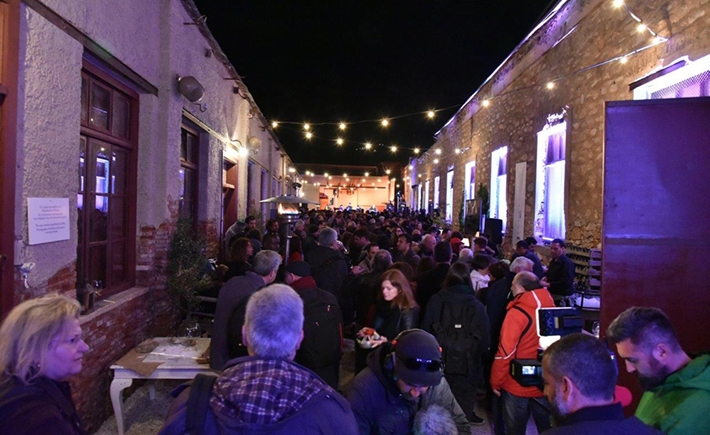 Το μεγάλο πλήθος συγκεντρωμένο έξω σε μια αυλή με έντονα φώτα από πάνω τους