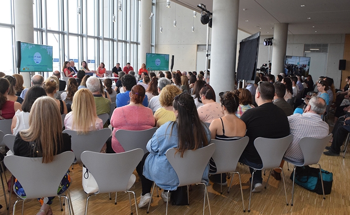 Audience at the SNF Dialogues looking at stage where there are seven speakers.