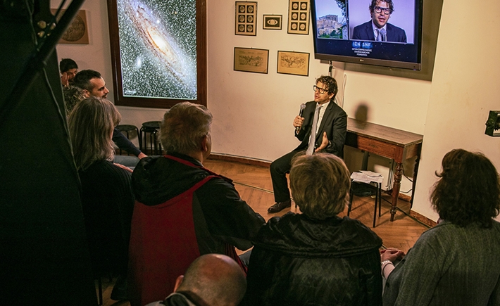 Ένας άνδρας που μιλάει στο μικρόφωνο με ανθρώπους μαζεμένους γύρω του για να ακούσουν