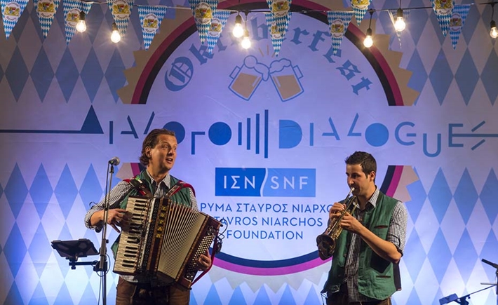 Two musicians playing in front of a vibrant background at the SNF Dialogues event 