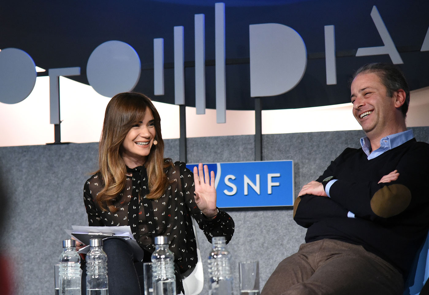 Anna-Kynthia Bousdoukou laughing with another guest at the SNF Dialogues event