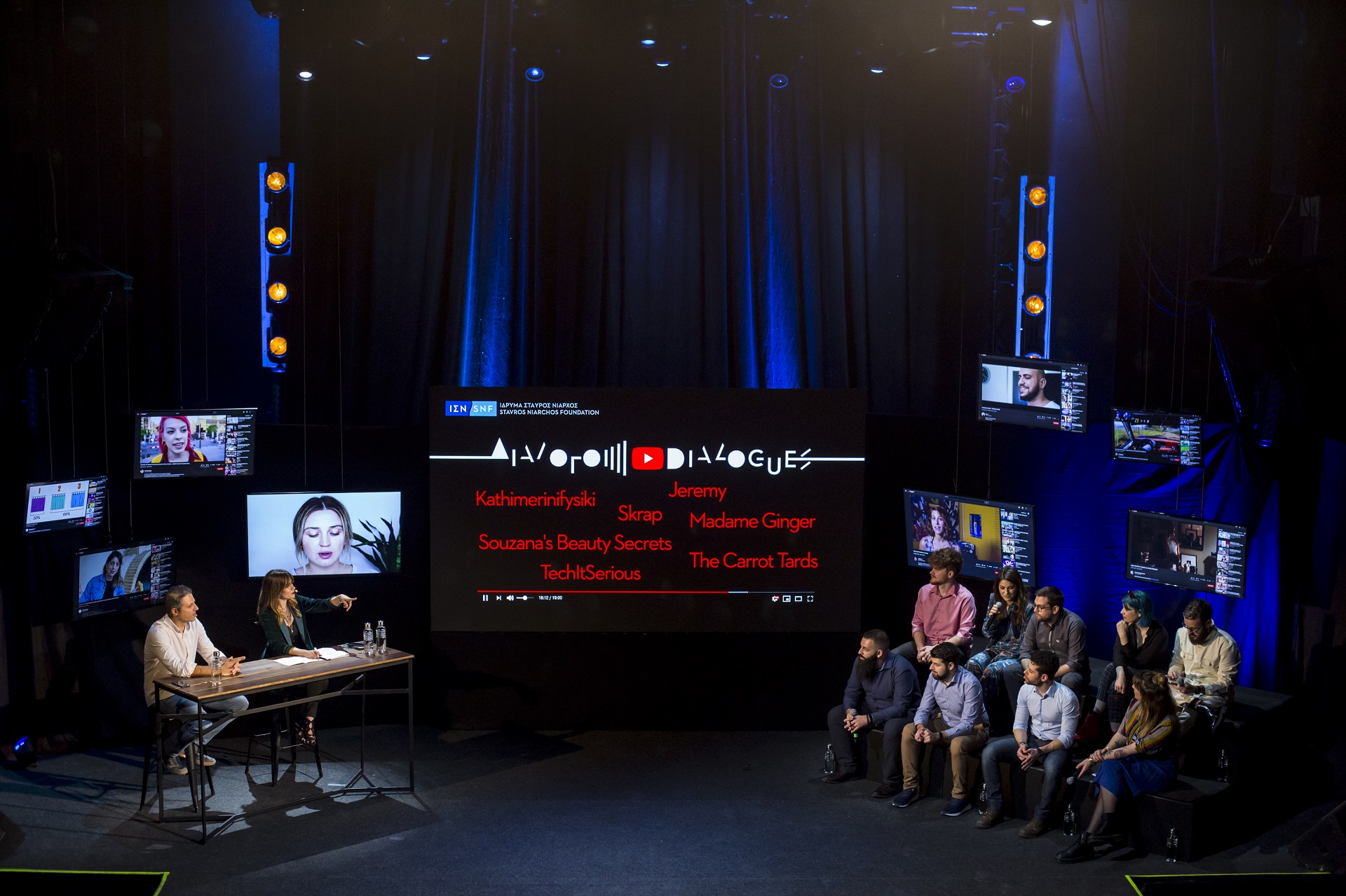 Άννα Κύνθια Μπουσδούκου και ομιλητές με μια μεγαλη οθόνη στη μέση στη συζήτηση των Διαλόγων ΙΣΝ.