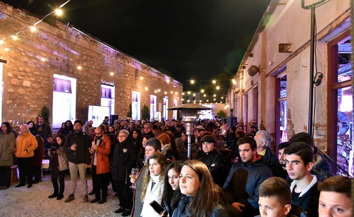 Το μεγάλο κοινό κάτω από έντονα φώτα που παρακολουθεί τους μουσικούς να παίζουν