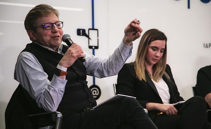 Ένας άνδρας που μιλάει στο μικρόφωνο και μια καλεσμένη δίπλα του στη συζήτηση των Διαλόγων ΙΣΝ