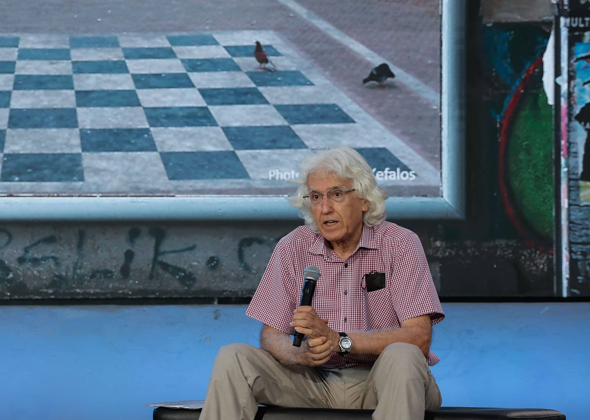 Man speaker holding the mic and speaks to the audience at the SNF Dialogues event.