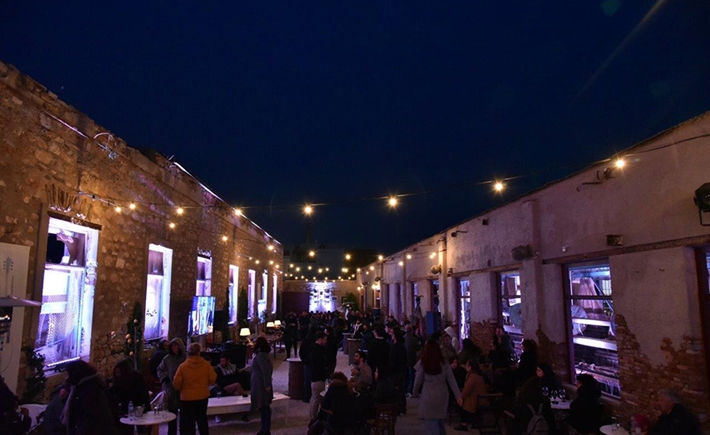 Η αυλή του κτιρίου με έντονα φώτα και κόσμο συγκεντρωμένο έξω