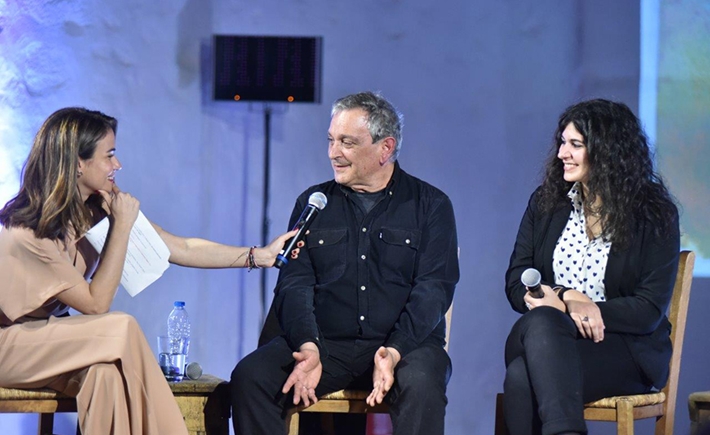 Anna-Kynthia Bousdoukou holding the microphone for another guest at the SNF Dialogues event