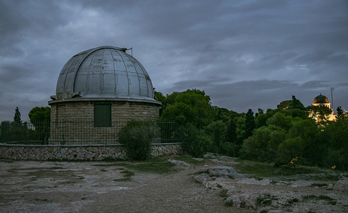 Φωτογραφία της οροφής του Εθνικού Αστεροσκοπείου Αθηνών κάτω από ένα πολύ σκοτεινό και συννεφιασμένο ουρανό