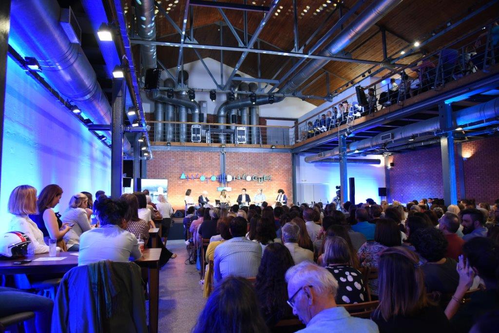 Ακροατές στη συζήτηση Διαλόγων ΙΣΝ που κοιτούν τη σκηνή όπου βρίσκονται αρκετοί ομιλητές.