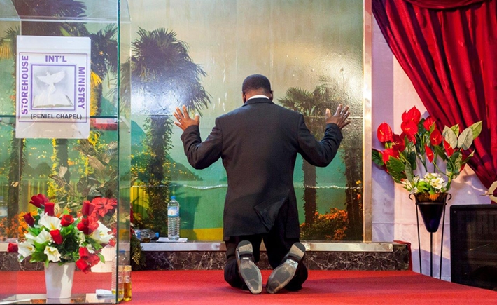 A man kneeling on the floor and praying