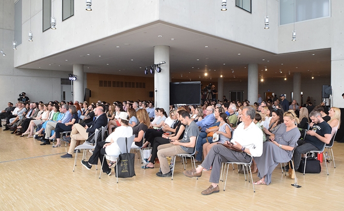 Big audience shot from the side sitting on chairs in a hall at the SNF Dialogues event.