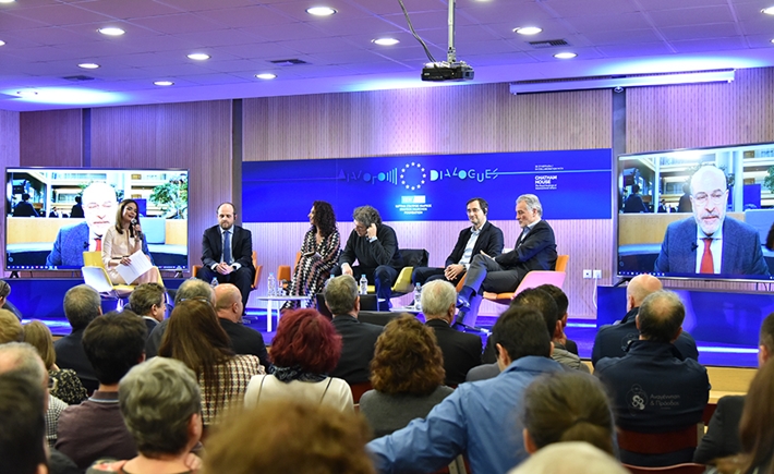 Anna-Kynthia Bousdoukou and the other guests on stage in front of a large screen while the crowd is listening to them at the SNF Dialogues event