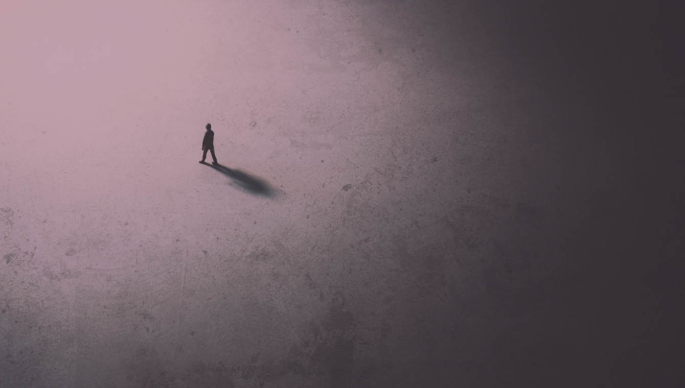 Banner showing a man walking alone towards the lighter part of the space.