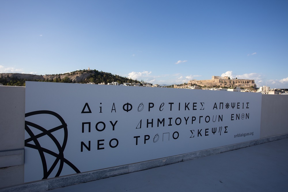 Η αφίσα για τους Διαλόγους ΙΣΝ στην πραγματικότητα με θέα την Ακρόπολη