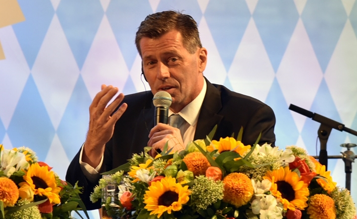 Photo of a man at the SNF Dialogues event in front of a bouquet of flowers