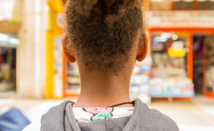 The back of the head of a young child with curly hair