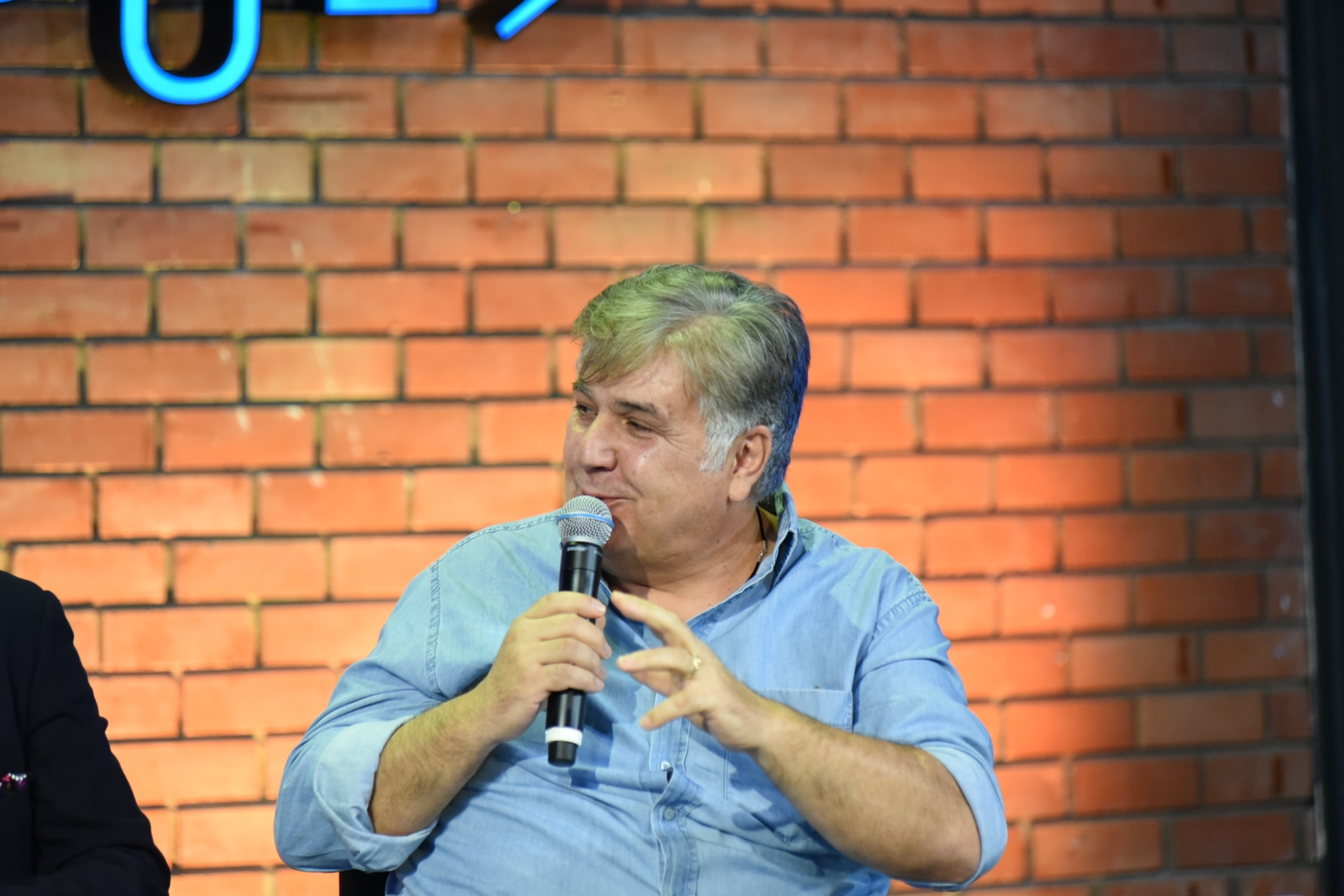 Άντρας ομιλητής κρατα το μικρόφωνο και μιλά στο κοινό στη συζήτηση των Διαλόγων ΙΣΝ.