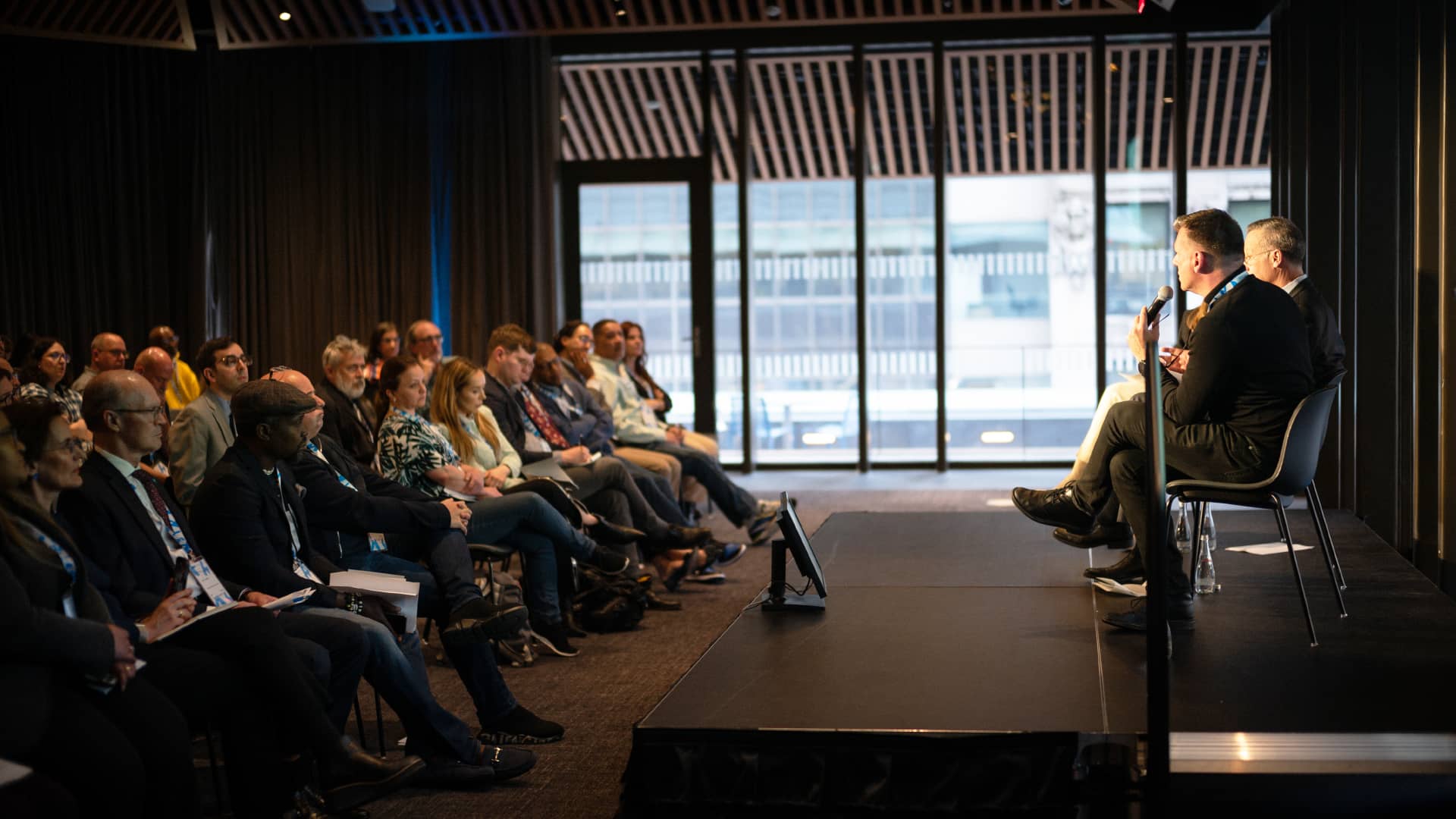 Speakers on stage addressing the audience at the SNF Dialogues event held at SNFL in NY.